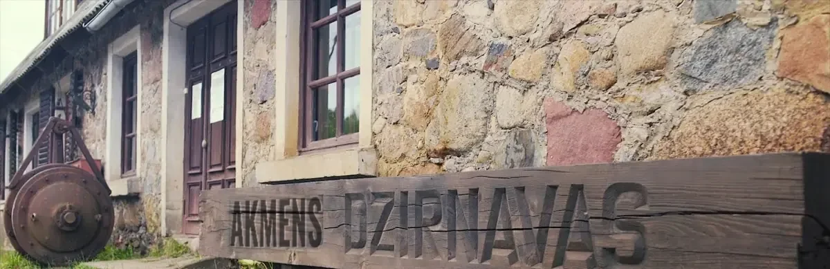 Kokā iegriezts uzraksts Akmens dzirnavas pie akmens mūra