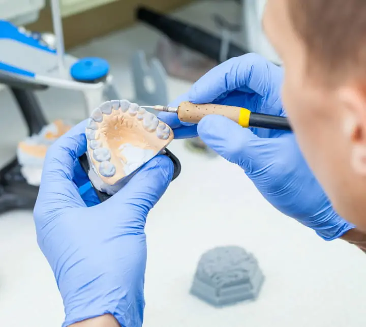 Zobu tehniķis klīnikas laboratorijā pārbauda zobu modeli