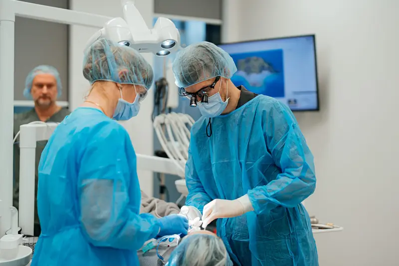 Ķirurgu komanda implantācijas operācijas laikā