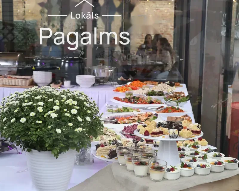 Klāts svētku galds ar ziediem un uzkodām