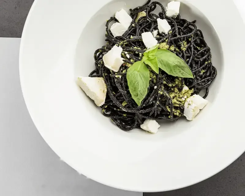 Melnie spageti ar kazas sieru un baziliku